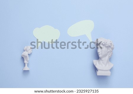 Bust David and Venus with dialog clouds on blue background. Minimal still life