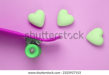 Skateboard with hearts on pink background. Love concept. Top view. Flat lay