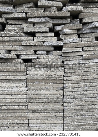 Stacked exposed aggregate concrete slabs photographed in black and white