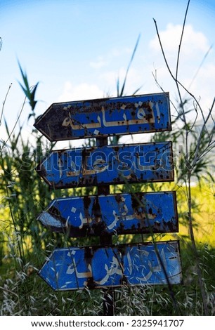 old and damaged blue road direction signs in the Lebanon mountains