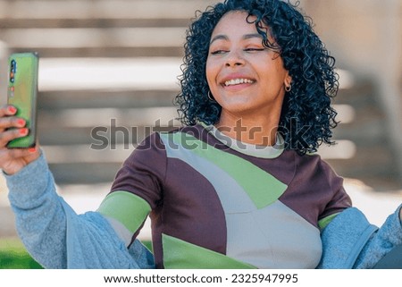 girl on the street with mobile phone recording or making selfie
