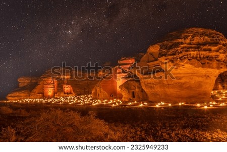 Starlight sky over the ancient nabataean tombs of Hegra city illuminated, night panorama, Al Ula, Saudi Arabia Royalty-Free Stock Photo #2325949233