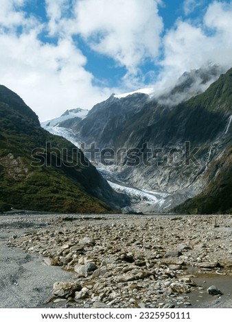 The picture shows the Franz Josef Glacier on the South Island of New Zealand on a slightly cloudy day. 