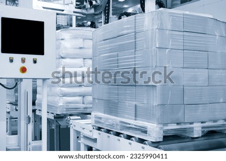 Cardboard boxes on a pallet wrapped in plastic wrap ready for delivery in a warehouse, logistics warehouse delivery concept background