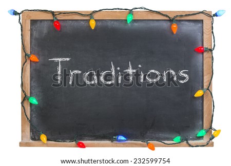Tradition written in white chalk on a black chalkboard surrounded with colored lights isolated on white