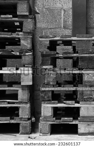 Stacked pallets in old factory in black and white