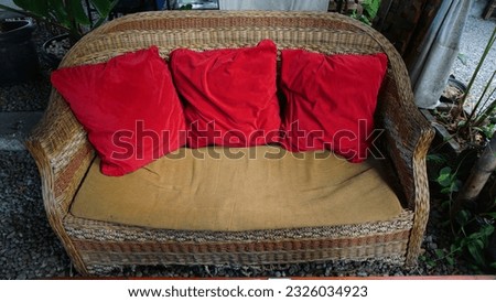 wicker chair with three red cushions
