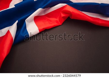 Part of the Norway flag is on a black background. Top view. Flat lay. Space for text.