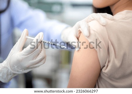 Close up of doctor making a vaccination in the shoulder of patient. coronavirus, Flu Vaccination Injection on Arm, covid-19 vaccine disease preparing for human clinical trials vaccination shot. Royalty-Free Stock Photo #2326066297