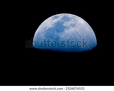 a stunning blue moon in the night sky, illuminated by its own light. The moon is seen from an aerial perspective, with no other objects or landmarks visible in the frame. Its round shape and bright.