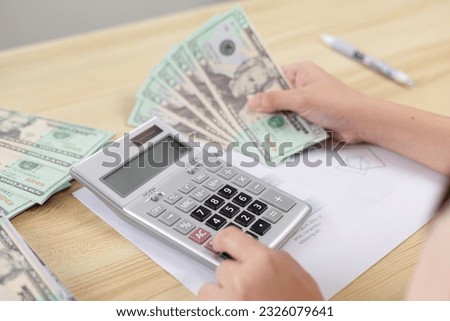 Young woman pressing the calculator for Calculate the money for her expenses. saving money and financial concept. ideas for growth, economy, business and investing. loan and mortgage concept.