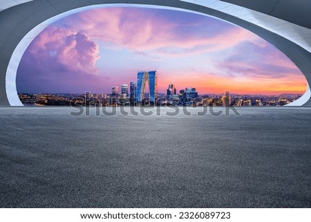 Asphalt road and city skyline with modern building at sunset in Suzhou, Jiangsu Province, China.