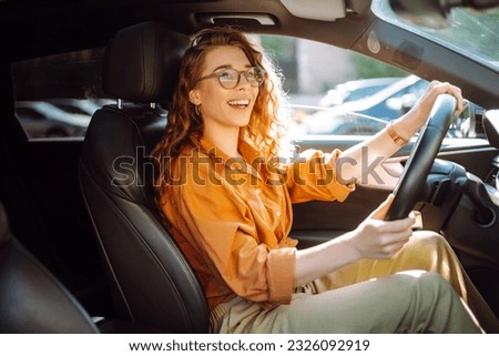 Smiling woman driving a car. Young traveler driving. Car travel, lifestyle concept. Royalty-Free Stock Photo #2326092919