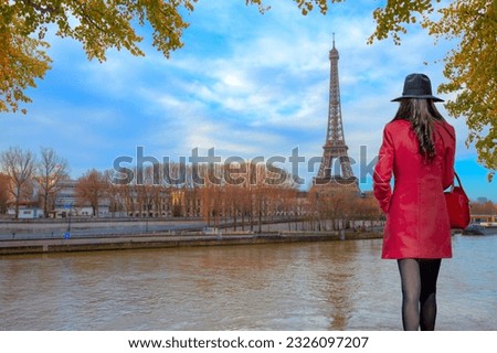Eiffel tower in Paris at sunset - Young woman in red clothes walking on the street