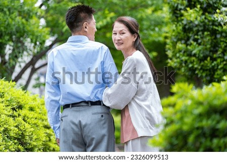Japanese couple looking back in the fresh green