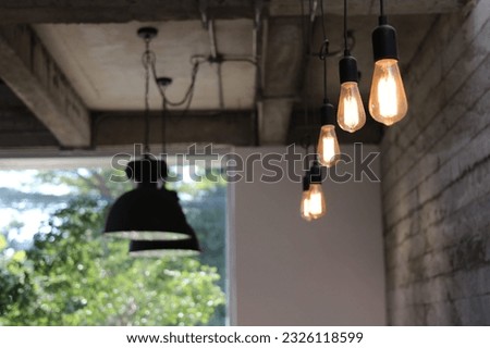 In a cozy café, elongated tubes suspended from the ceiling. These are the enchanting light fixtures that grace the café's interior, casting a warm and inviting ambiance throughout the space. Royalty-Free Stock Photo #2326118599