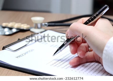 Doctor  in a white labcoat writing out RX prescription