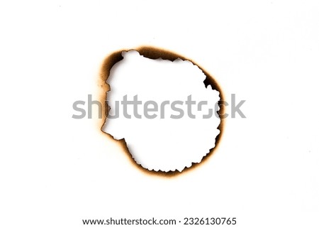 burnt holes in a piece of paper isolated on white background Royalty-Free Stock Photo #2326130765