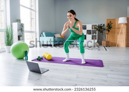 Full length portrait of attractive girl use rubber expander squat watch video netbook morning activity indoors Royalty-Free Stock Photo #2326136255