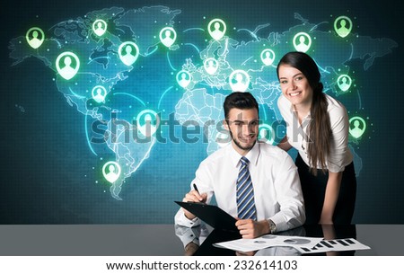 Business couple sitting at table with social media connection symbols on the world map 
