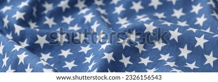Close-up of blue wavy fabric with white stars texture background. Stars seamless pattern backdrop