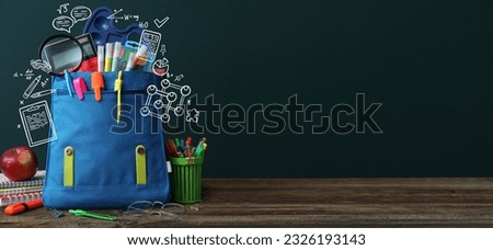 School backpack with stationery on table in classroom. Banner for design Royalty-Free Stock Photo #2326193143