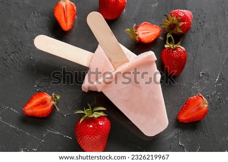 Sweet strawberry ice-cream popsicles on black background