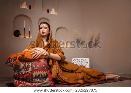 beautiful young woman in indian dress sitting on pillows, selective focus
