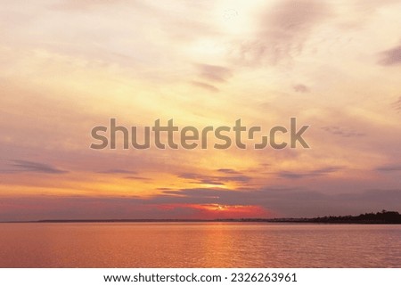 Colorful sky background on sunset, orange blue vivid color clouds and surface water on lake Ik. Nature abstract fon with reflections on water, natural shades cloudscape, nature environment skyline