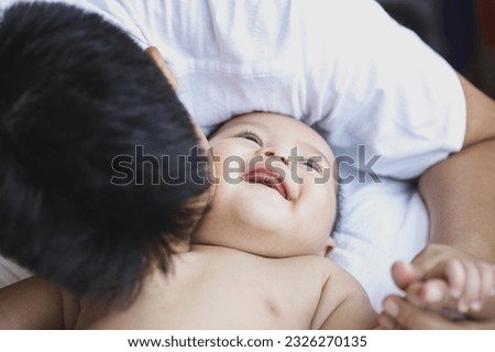 Loving father and son cuddling at home, enjoying fatherhood, parenthood.