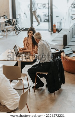 Mature businessman giving tips and tricks to his female employee for better efficiency at work