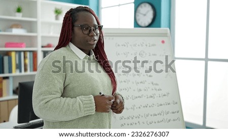 African woman with braided hair teacher teaching maths lesson at university library Royalty-Free Stock Photo #2326276307