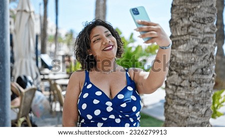 Young beautiful latin woman smiling confident making selfie by the smartphone at coffee shop terrace