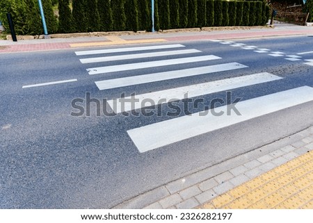 Crosswalk on the road for safety when people walking cross the street.Zebra crossing on outdoor road.Outdoors shot.Summer day.