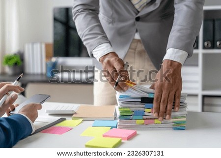 Businesswoman working in stacks of paperwork files for searching infomation unfinished documents about pile audit form on desk office and investigate financial doc in busy workload