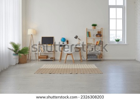 Children's study room at home. Modern spacious interior with desk, chair, bookshelves, chalkboard, lamps, Earth globe, plants, boxes, toys, rug, and laminate flooring. Unisex design for boy or girl Royalty-Free Stock Photo #2326308203