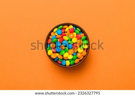 Multicolored candies in a bowl on a colored background. birthday and holiday concept. Top view with copy space. Royalty-Free Stock Photo #2326327795