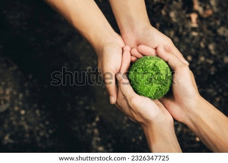 World Earth Day Concept.Hands of People Embracing green earth. Green Energy, ESG, Renewable and Sustainable Resources. Environmental Care. Protecting Planet Together.Saving environment. Save Earth. Royalty-Free Stock Photo #2326347725