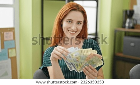 Young redhead woman business worker counting romanian leu banknotes smiling at office Royalty-Free Stock Photo #2326350353