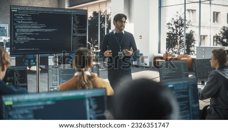 Teacher Giving Class to Diverse Multiethnic Group of Female and Male Students in College Room, Learning New Academic Skills on a Computer. Lecturer Shares Knowledge with Smart Young Scholars Royalty-Free Stock Photo #2326351747
