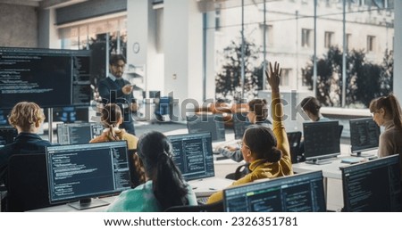 Portrait of a Young Inspired Black Female Student Studying in College with Diverse Classmates. African Girl Asking Teacher a Question. Girl Using Computer to Acquire IT Skills in Class Royalty-Free Stock Photo #2326351781