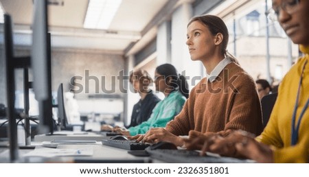 Young Smart Female Student Studying in Modern School with Diverse Multiethnic Classmates. Happy College Scholars Work in College Room, Learning IT, Programming or Computer Science. Royalty-Free Stock Photo #2326351801