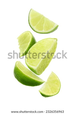 Fresh lime slices falling on white background