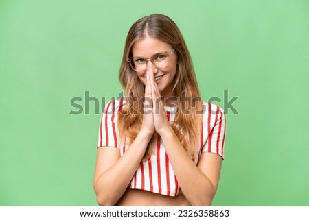 Young beautiful woman over isolated background keeps palm together. Person asks for something