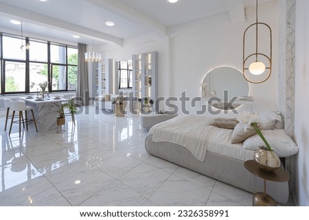minimalistic light elegant luxury design of a modern spacious studio apartment with kitchen area, bedroom and huge mirror behind the couch. tiles on the floor and high ceiling. Royalty-Free Stock Photo #2326358991