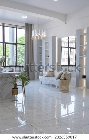 minimalistic light elegant luxury design of a modern spacious studio apartment with kitchen area, bedroom and huge mirror behind the couch. tiles on the floor and high ceiling.