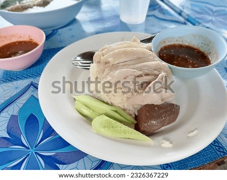 a photography of a plate of food with a fork and a bowl of sauce, there is a plate of food with meat and vegetables on it