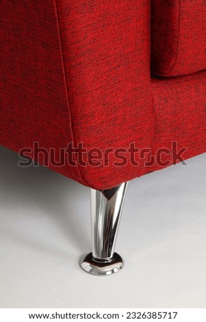 detail of chrome leg of elegant red furniture