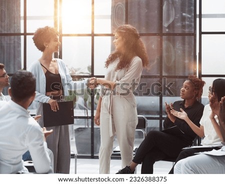 Welcome aboard. Group of business people sitting on a chair while two people shake hands