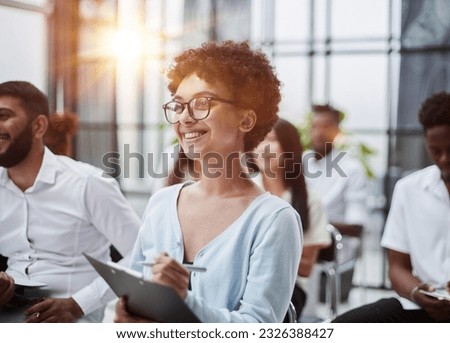 Group of different employees studying at board meeting in modern office or conference room